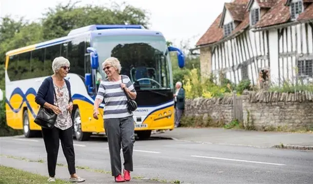Two women walking by Johnsons coach