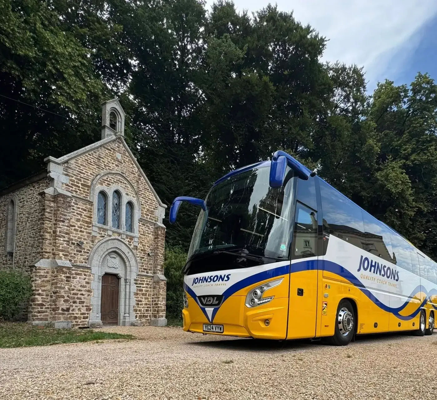 Coach parked by building in lane