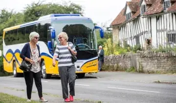 Two women walking by Johnsons coach